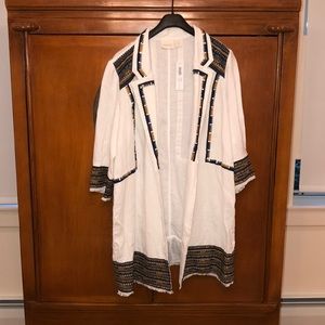 All white jacket with multi colored Aztec border .